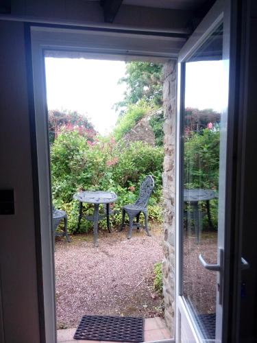 an open door to a patio with a table and chairs at Domaine du mont scolan in Montgardon