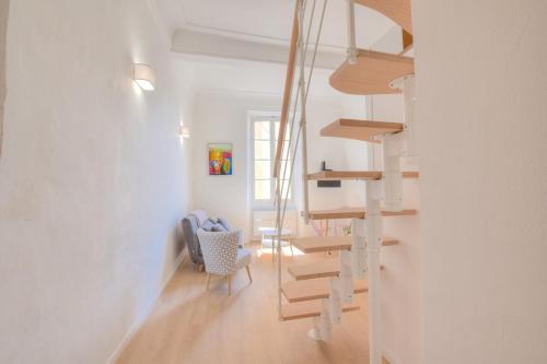 une chambre blanche avec un escalier en colimaçon et une chaise dans l'établissement Cosy apartment Vieil Antibes, à Antibes