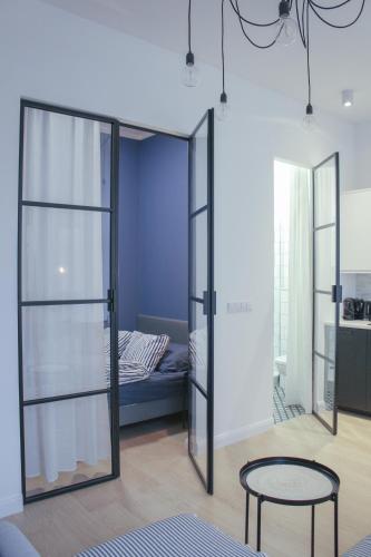 a room with a bed and a table and glass doors at Apartament Andersa in Sopot