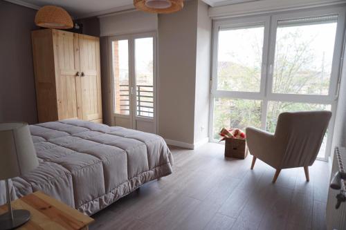 1 dormitorio con 1 cama, 1 silla y 1 ventana en Casa La Solana, en Bolaños de Campos