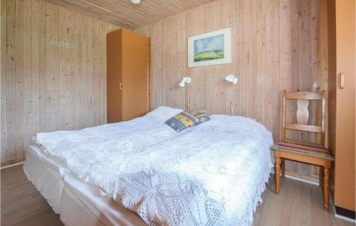 um quarto com uma cama e uma parede de madeira em Beautiful Home In rsted With Kitchen em Ørsted