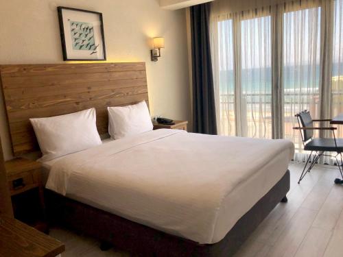um quarto de hotel com uma cama grande e uma varanda em 8 Rooms Hotel em Gelibolu