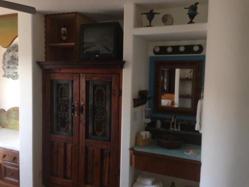 a bathroom with a sink and a tv on a cabinet at Secret Garden Inn in San Diego