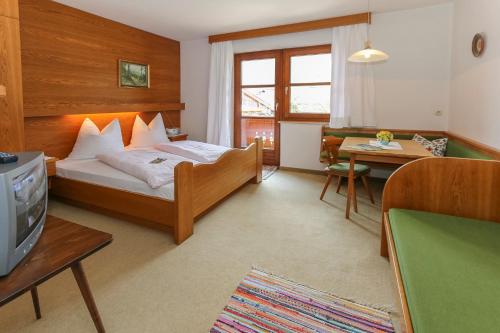 um quarto de hotel com uma cama e uma televisão em Hagerhof em Walchsee