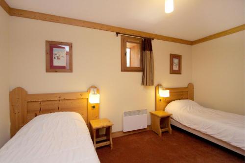 - une chambre avec deux lits et deux lumières allumées dans l'établissement Bel appartement 6 à 8 personnes au pied des pistes, à Les Deux Alpes