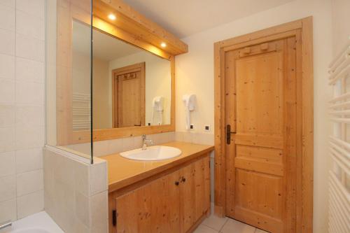 une salle de bain avec un lavabo et un miroir dans l'établissement Bel appartement 6 à 8 personnes au pied des pistes, à Les Deux Alpes