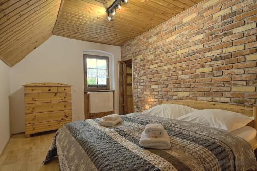 ミウクフにあるApartament w Karkonoszachのレンガの壁とベッドが備わるベッドルーム1室が備わります。