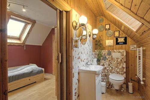 a bathroom with a toilet and a sink and a bed at Apartament w Karkonoszach in Miłków