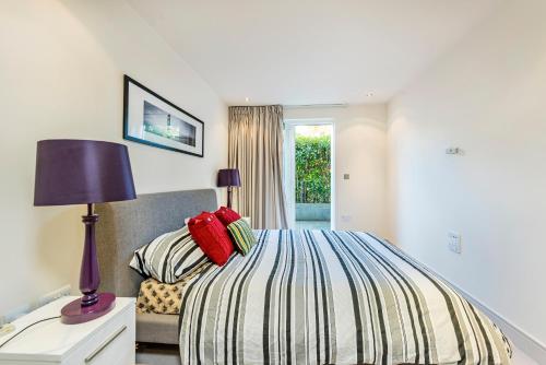 ロンドンにあるChelsea - Executive Apartmentのベッドルーム(ベッド1台、ランプ、椅子付)