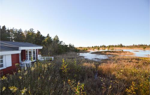 a small house in a field next to a river at Gimle in Bolilmark