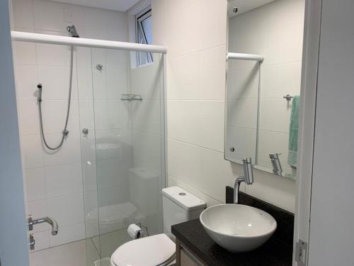 La salle de bains est pourvue d'une douche, de toilettes et d'un lavabo. dans l'établissement Apartamento de frente para Piscina, com vista para o mar, à Florianópolis