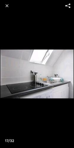 a kitchen with a sink and a stove top at Cosy village in Bonneuil-en-France