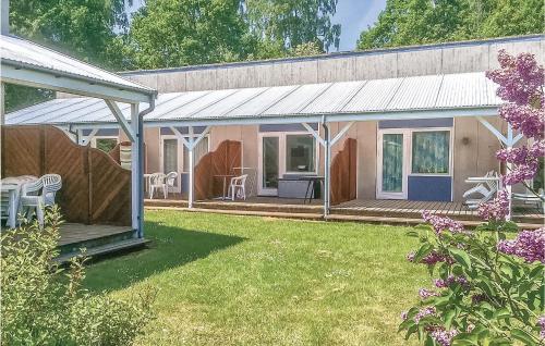 une maison avec un porche et une cour avec des fleurs violettes dans l'établissement Beautiful Apartment In Nexø With Sauna, à Strandby Gårde