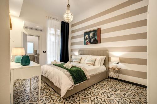 um quarto com uma cama e uma parede listrada em AwesHomeItaly - Cinque Terre Fancy em La Spezia