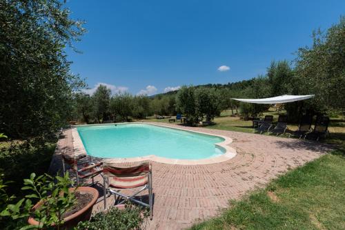 una piscina con sillas y sombrilla en Villa Le Pergole- Firenze, en Florencia