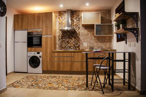 a kitchen with a counter and a washer and dryer at Casa Cueva El Arrabal in Setenil