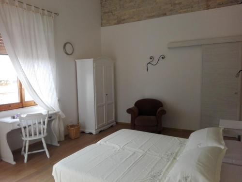 - une chambre avec un lit, un bureau et une chaise dans l'établissement Bed and Breakfast San Saturnino, à Cagliari