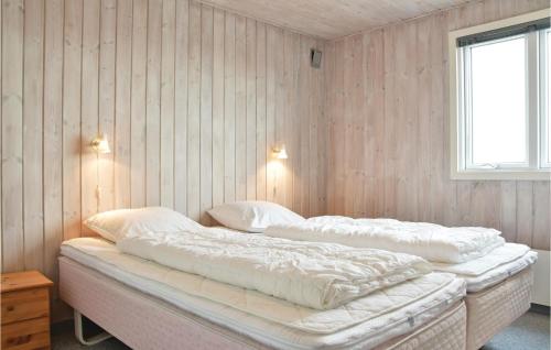 - une chambre avec 2 lits avec des draps blancs et une fenêtre dans l'établissement 3 Bedroom Cozy Home In Hvide Sande, à Havrvig