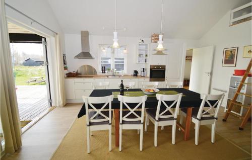 a kitchen with a table and chairs and a kitchen with white cabinets at Holiday Home Ternevangen Denmark X in Nysted