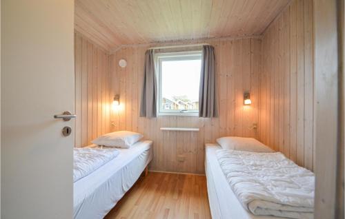 two beds in a small room with a window at Skærbæk Fritidscenter in Skærbæk