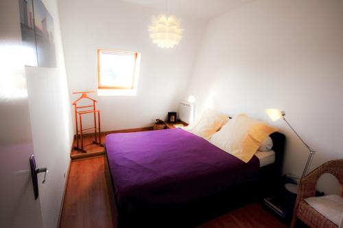 - une chambre avec un lit et une couverture violette dans l'établissement Appart très sympa à St Aubin sur Mer, à Saint-Aubin-sur-Mer