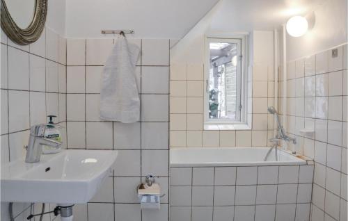 ein weißes Badezimmer mit einem Waschbecken und einer Badewanne in der Unterkunft Gorgeous Apartment In Tisvildeleje With Kitchen in Tisvildeleje