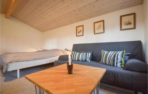 エーベルトフトにあるBeautiful Home In Ebeltoft With Wifiのリビングルーム(青いソファ、ベッド付)