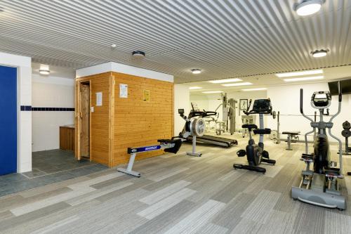 a gym with several treadmills and exercise bikes at The Anchorage Apartments in Mount Maunganui