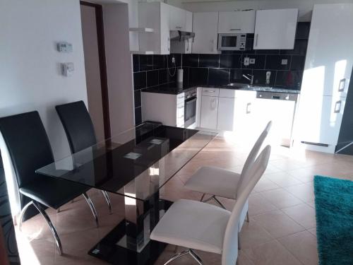 a kitchen with a glass table and chairs at Apartmán U Zlatého křížku in Velké Meziříčí