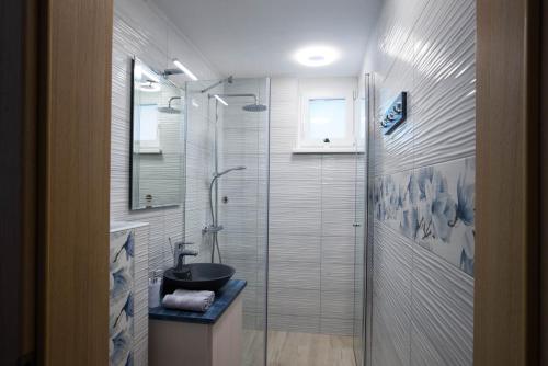 a bathroom with a shower with a sink and a toilet at ALEX BUMBLEBEE in Bled