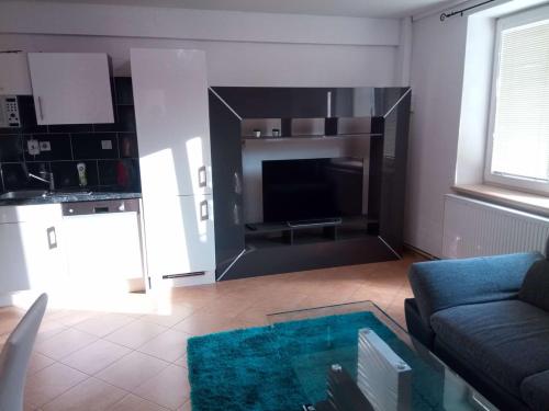 a living room with a couch and a tv at Apartmán U Zlatého křížku in Velké Meziříčí