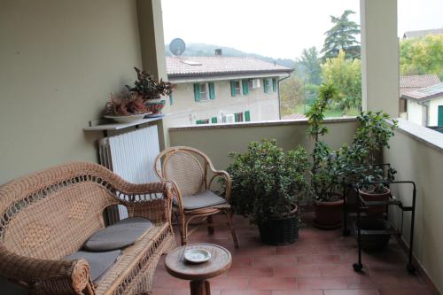 a balcony with two wicker chairs and a couch at Le Ruote in Vezzano sul Crostolo