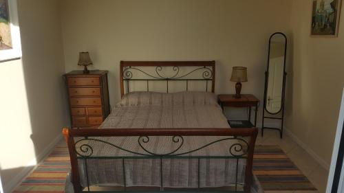 a bedroom with a bed and a dresser and a mirror at La Maison du Pontac in Villenave-dʼOrnon