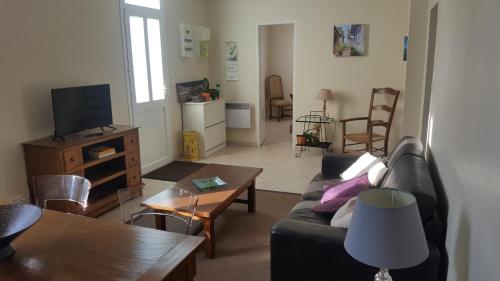 a living room with a couch and a table at La Maison du Pontac in Villenave-dʼOrnon