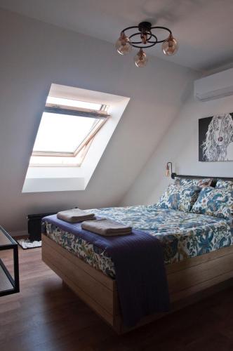 a bedroom with a bed and a skylight at Apartment City View in Sofia