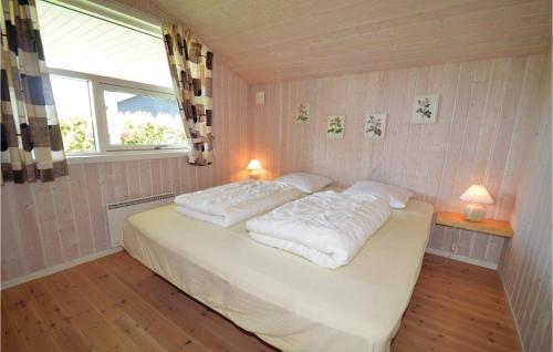 1 dormitorio con 1 cama con 2 almohadas y ventana en Beautiful Home In Bog By With 3 Bedrooms, Sauna And Wifi, en Bogø By