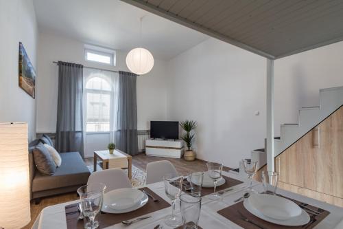 a dining room with a table and chairs and a living room at Apartamenty INTERDOM in Zakopane