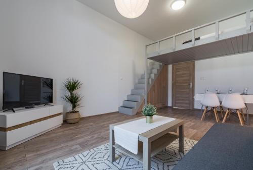 a living room with a television and a staircase at Apartamenty INTERDOM in Zakopane