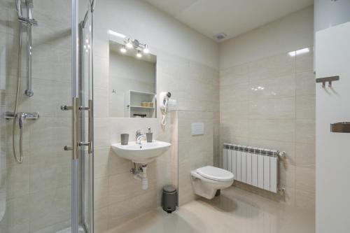 a bathroom with a toilet and a sink and a shower at Apartamenty INTERDOM in Zakopane