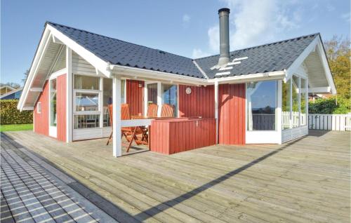 a red and white house with a deck at Holiday Home Bygmarken V in Sønder Bjert
