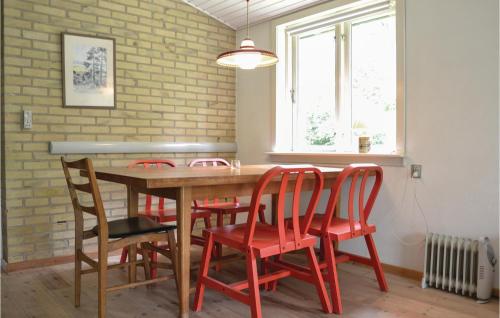 a dining room table with red chairs and a brick wall at Holiday Home Elenavej Frederiksv in Frederiksværk