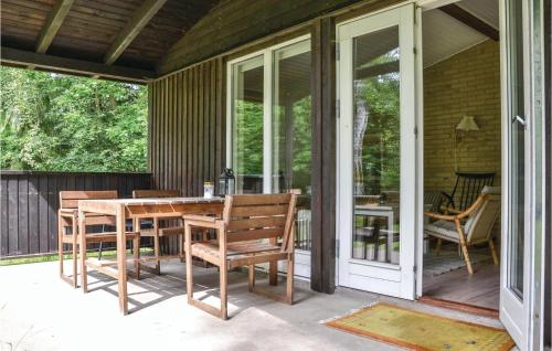 a screened in porch with a table and chairs at Holiday Home Elenavej Frederiksv in Frederiksværk