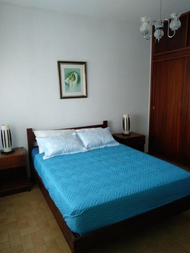 a bedroom with a bed with a blue comforter at Home Village in Vila do Bispo