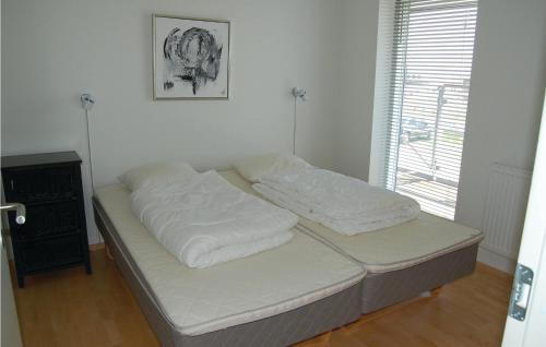 a bed with white sheets on it in a room at Pet Friendly Apartment In Rm With Wifi in Rømø Kirkeby