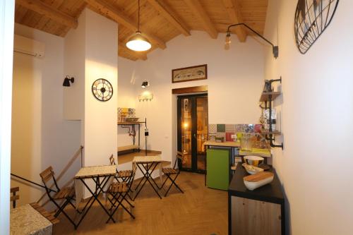 een keuken en een woonkamer met een tafel en stoelen bij Torre's Camere & caffè in Monreale