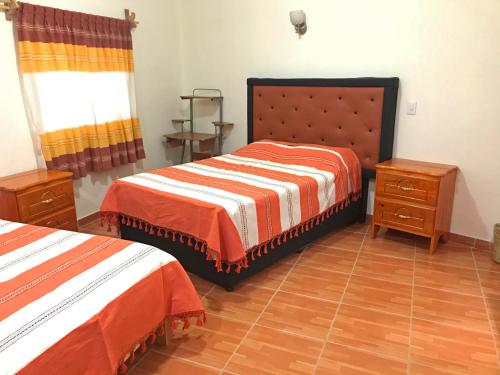 a bedroom with two beds and two night stands at Casa Elim-Oaxaca in Teotitlán del Valle