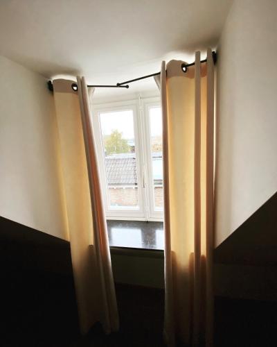 a window in a room with curtains in front of a window at Chambres D'Hotes Rekko in Maastricht