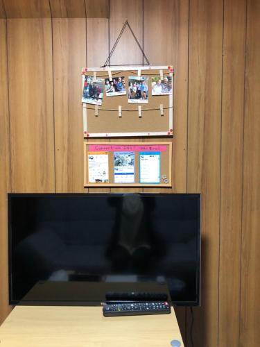a computer monitor and a remote control on a table at Masaru House in Osaka
