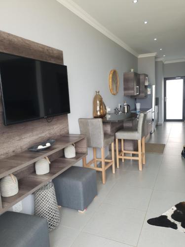 a living room with a television on a wall at Bayview Suites, Unit 9, Room # 13 in Langstrand