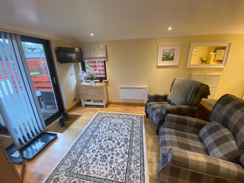 a living room with two couches and a rug at The Wee Ludging Cottage, Rashfield, by Dunoon in Dunoon